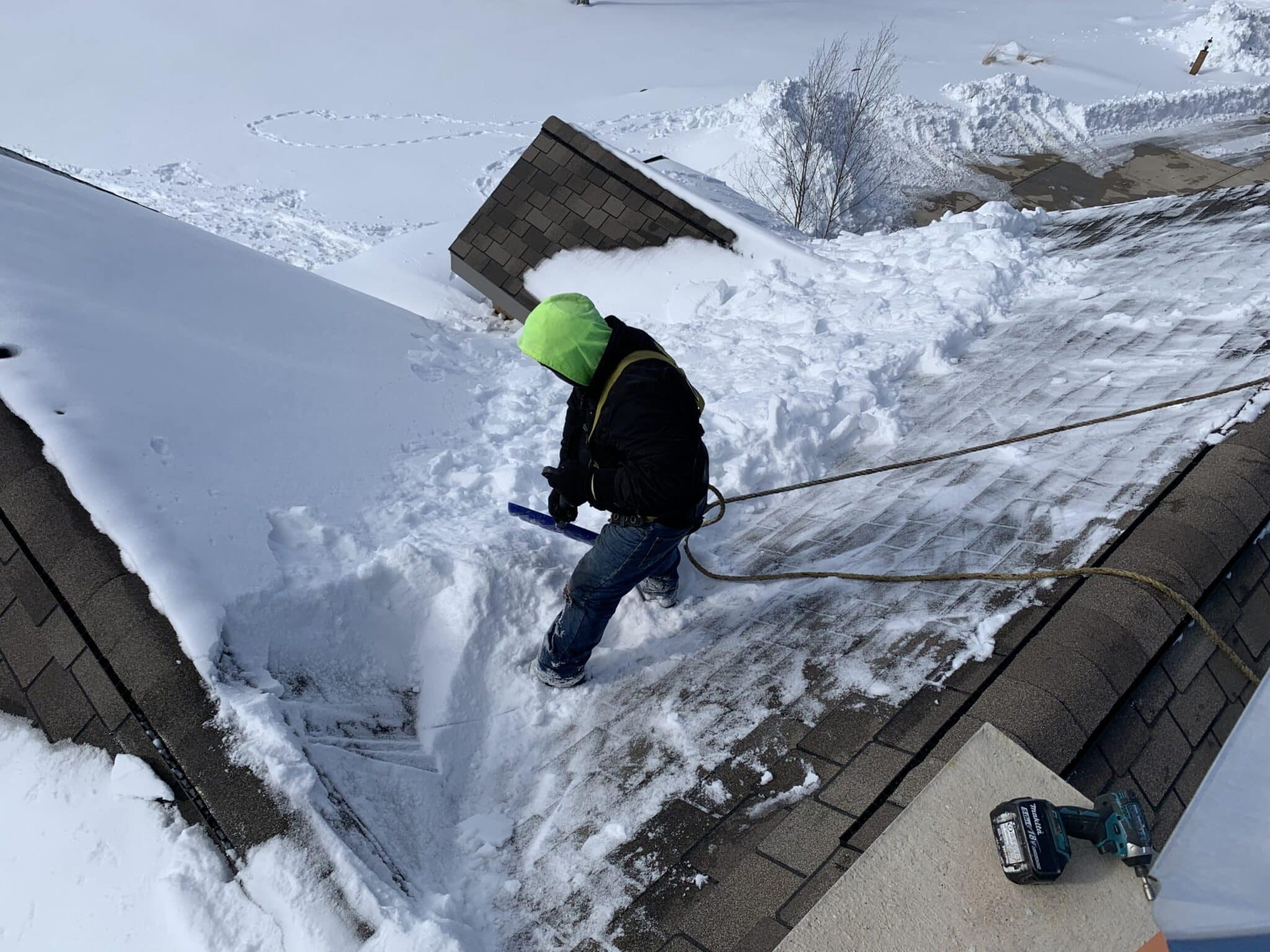 Worker almost finished shoveling snow from roof